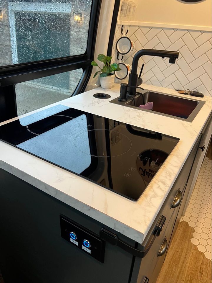  and adventure sign for your travels.|Sleek RV rental kitchen: induction cooktop — photo 2