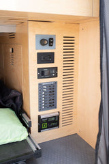 RV rental's electrical hub: Xantrex inverter, Blue Sea DC panel for lights/appliances, plus a Zamp Solar charge controller. Van power management.