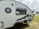 Side exterior view of a grey teardrop Boondock RV with a mountain decal. Perfect for an rv rental, parked outdoors in Sherman, TX.
