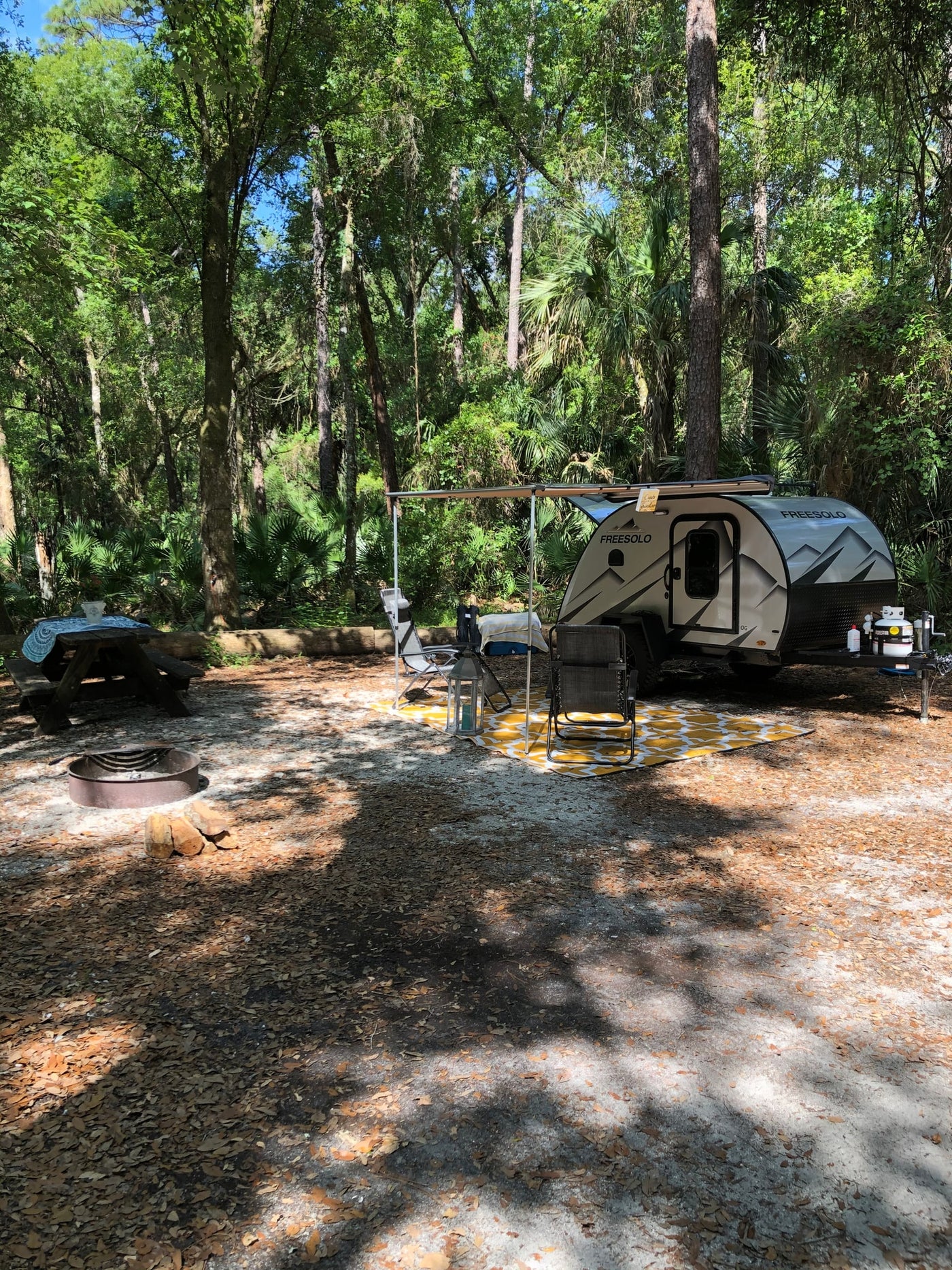 Scenic rv rental campsite with a Freesolo teardrop trailer, picnic table, and fire pit nestled in nature. — photo 15