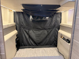RV rental interior showing compact bunk beds, overhead mesh storage, and a black fabric divider for an organized space.