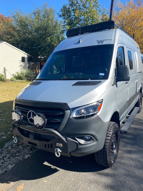 Rugged Mercedes-Benz Sprinter rv rental, perfect for adventure. Features custom bumper, auxiliary lights, and roof rack.