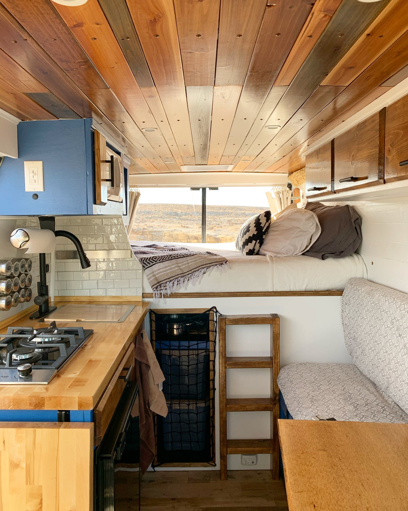 This RV rental boasts a full kitchen, comfy bed, storage, and stunning desert views through the rear window. Van life ready!