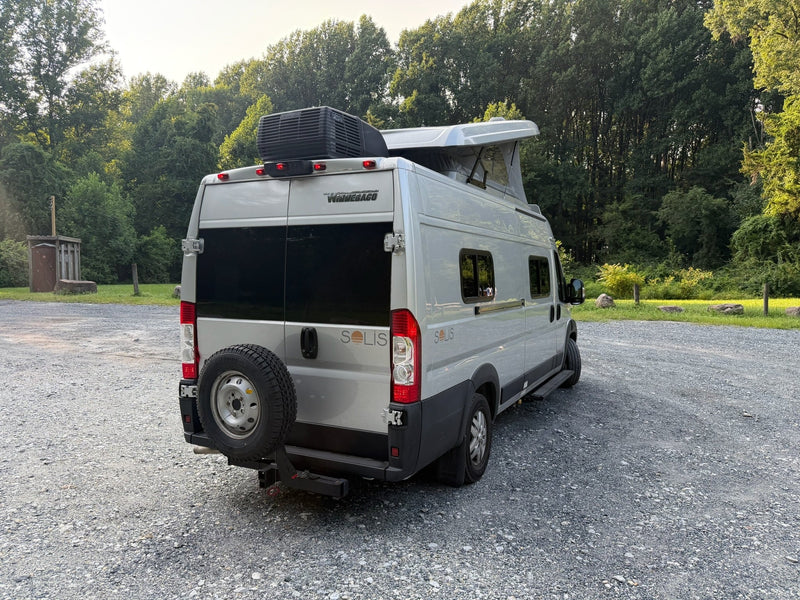  and a window with a scenic green view from the camper van.|Inside a bright RV rental: gray front seats — photo 14