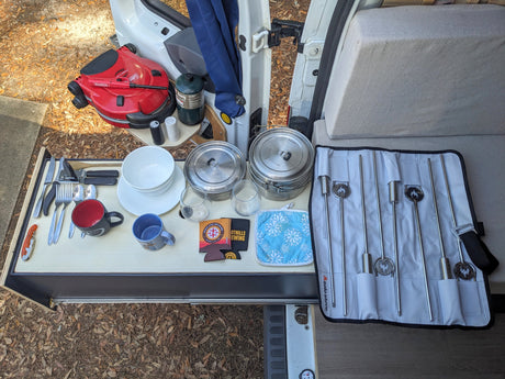 RV rental camping kitchen setup: portable grill, Solo Stove cookware, utensils, and skewers, ready for outdoor meals.