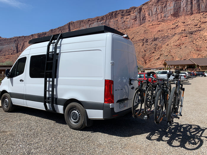 White Sprinter van rv rental equipped with bikes, perfect for exploring red rock landscapes.