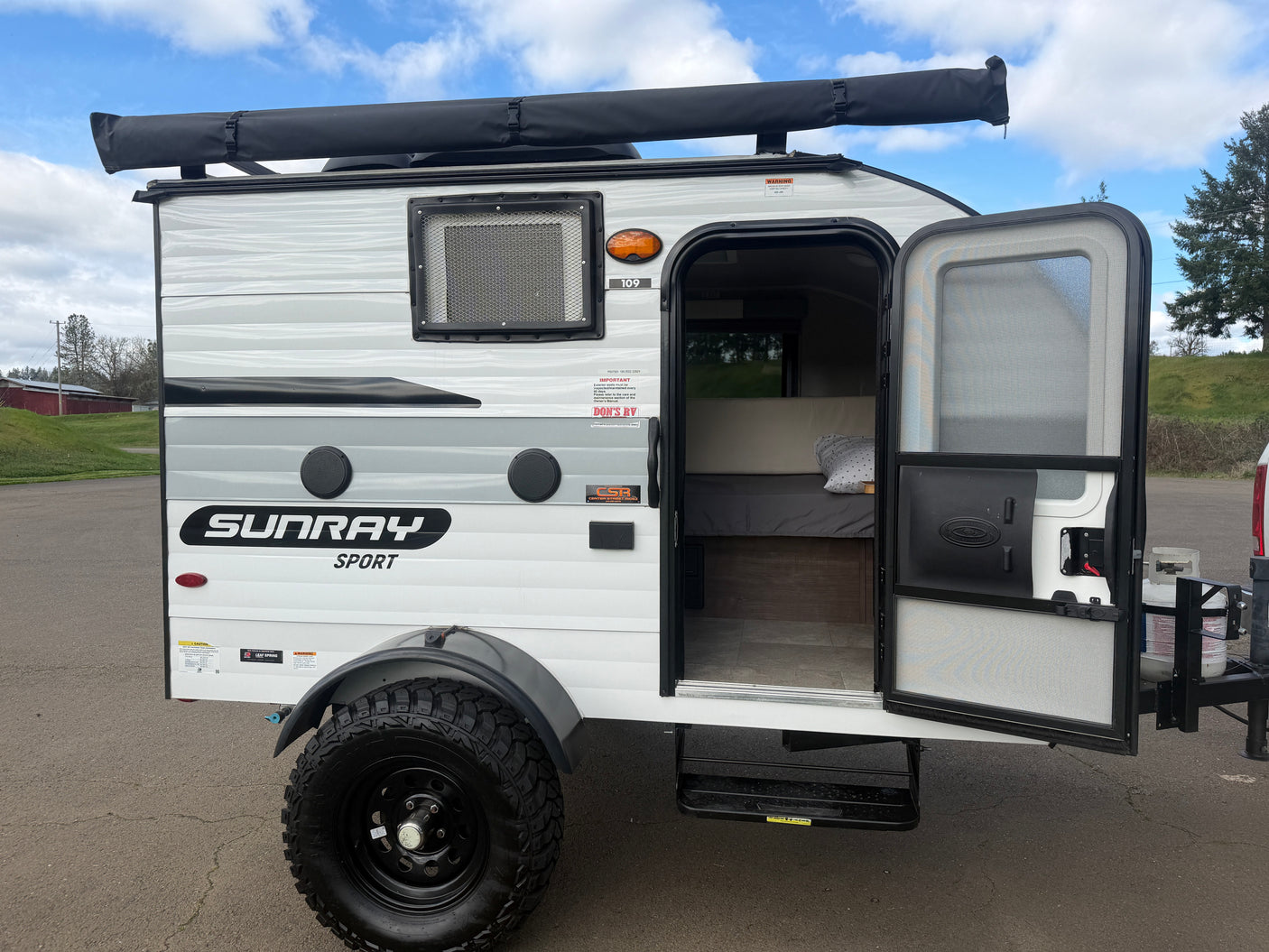This Sunray Sport travel trailer is a compact RV rental, ideal for adventure. It features an awning & rugged off-road tires.