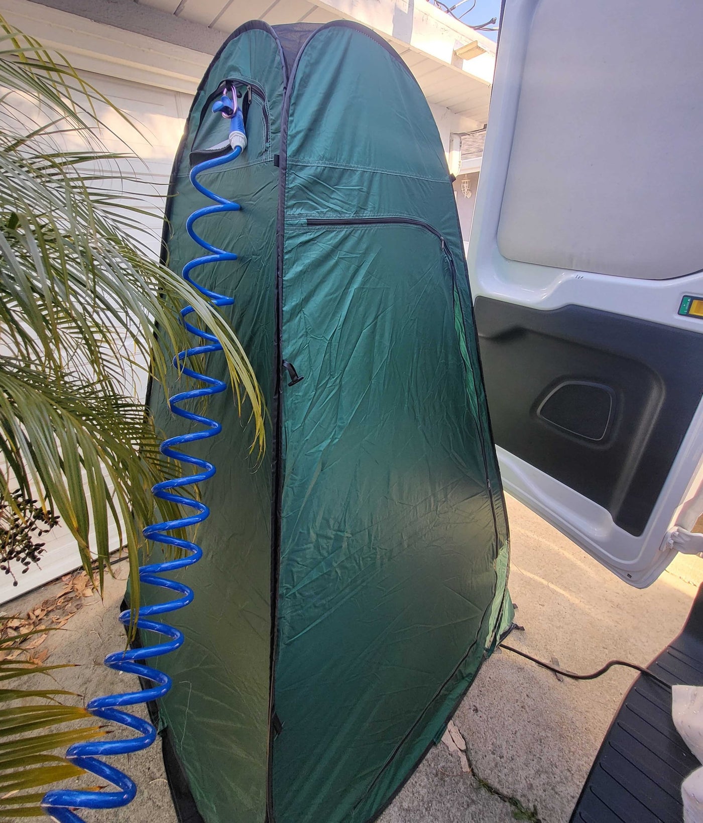 Green privacy tent with coiled blue shower hose & power cord, ideal for an RV rental outdoor shower setup. — photo 16