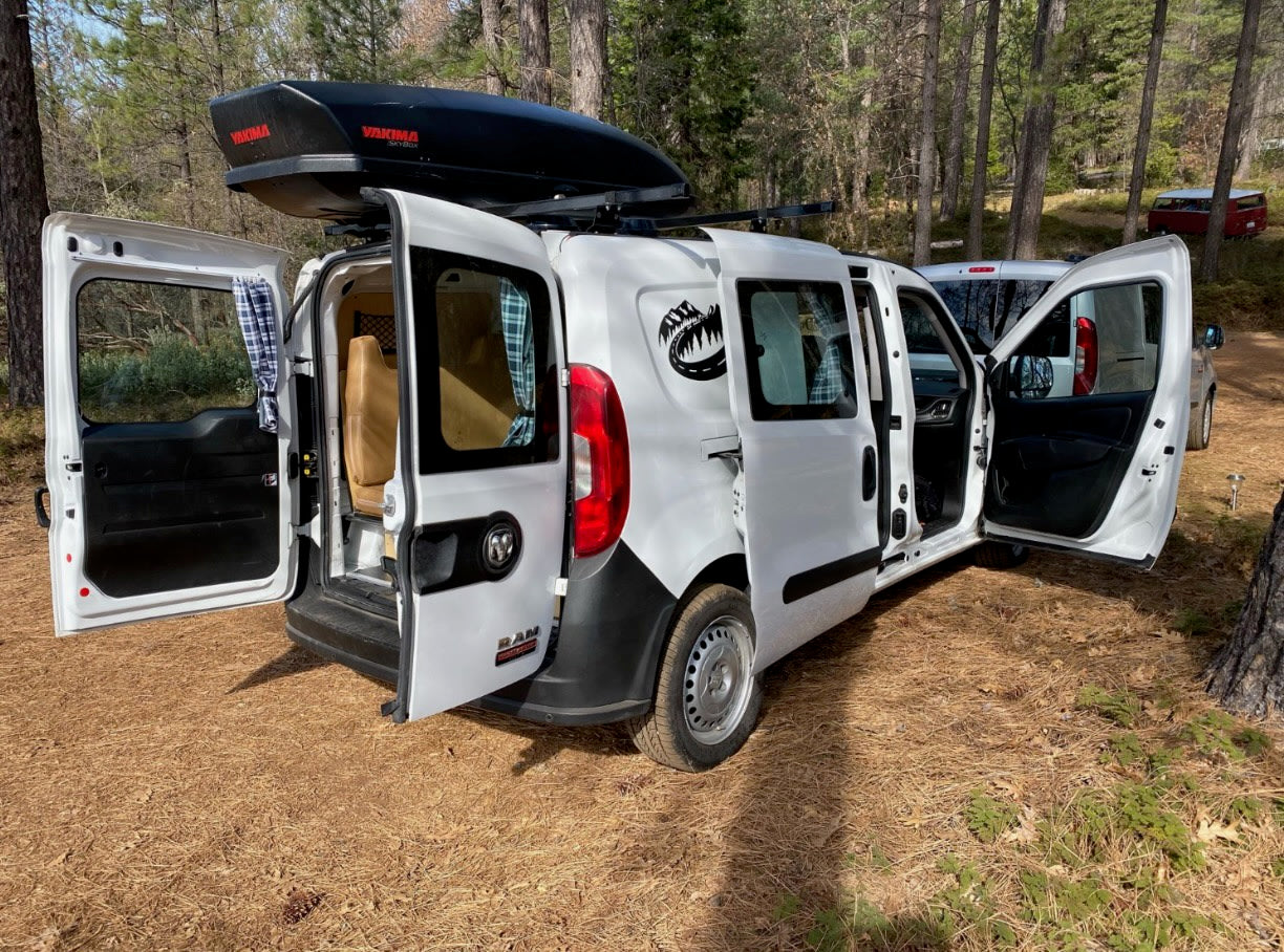  and storage unit with portable fridge.|This RV rental camper van features a cozy bed with plaid curtains — photo 4