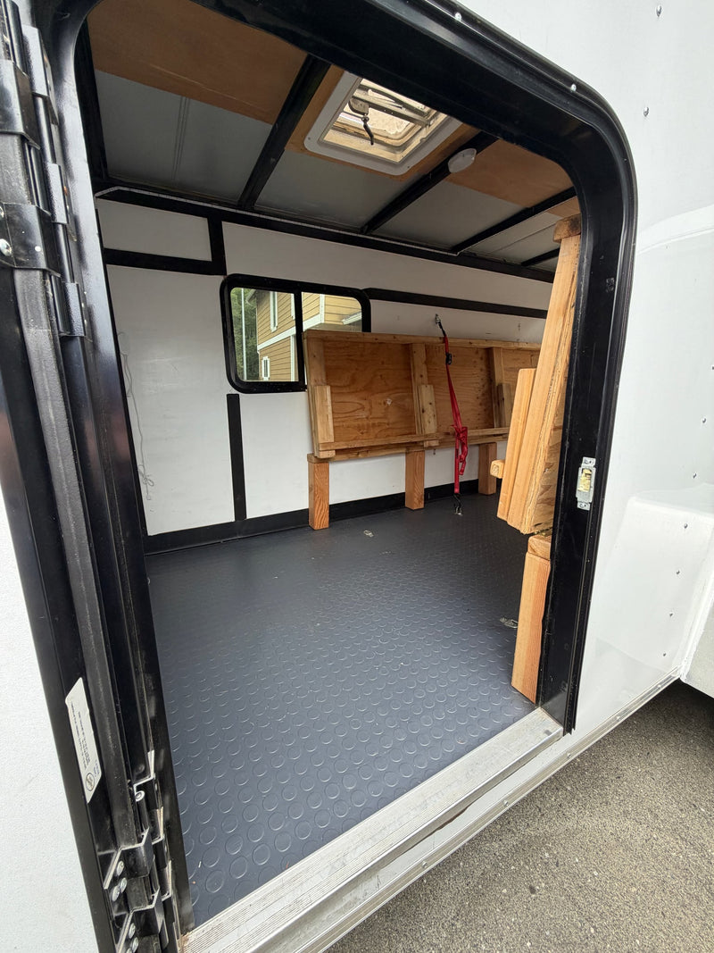  parked in a driveway next to a house and SUV.|A compact white cargo trailer — photo 7