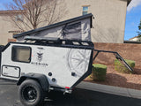 This Mission Overland off-road teardrop camper with a pop-up tent and custom graphics is ideal for an RV rental, camping, or overland journey.