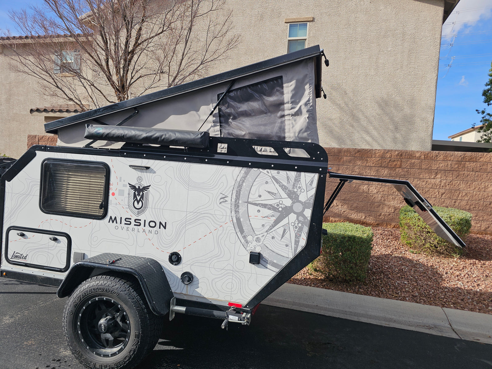 This Mission Overland off-road teardrop camper with a pop-up tent and custom graphics is ideal for an RV rental, camping, or overland journey.