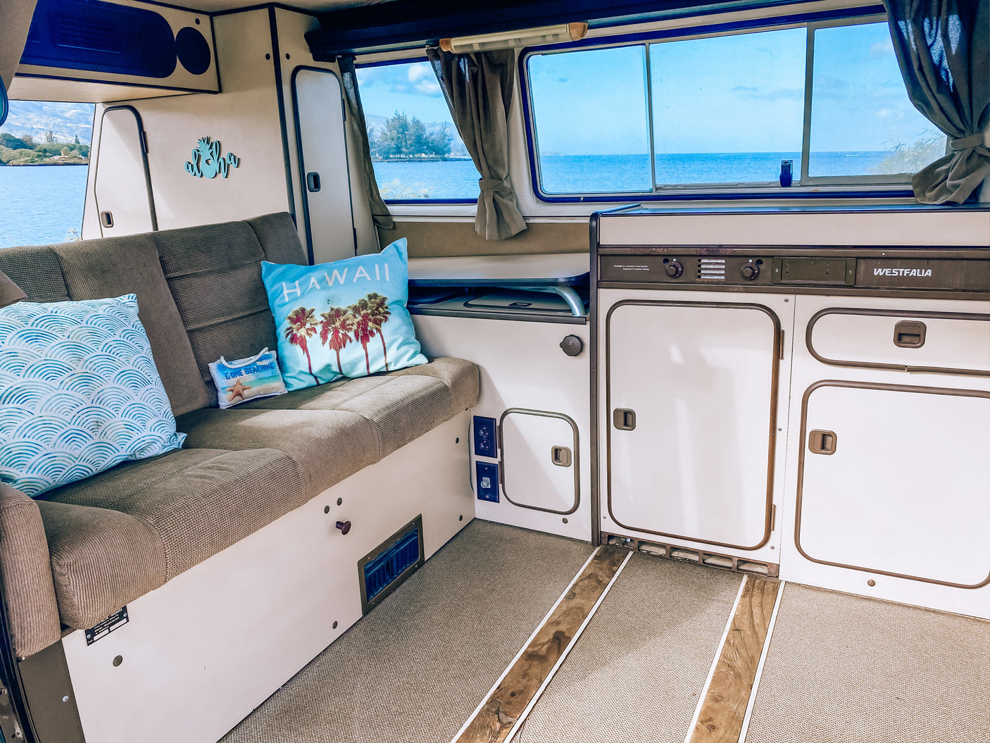 Spacious Westfalia camper van interior, perfect for your next rv rental. Enjoy the serene ocean view from your mobile home.