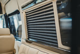 RV rental: Inside, luxurious beige leather seats and closed dark pleated window blinds ensure privacy.