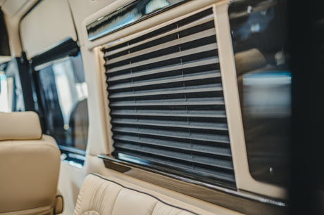 RV rental: Inside, luxurious beige leather seats and closed dark pleated window blinds ensure privacy.