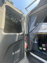 RV rental's open rear door reveals an outdoor shower, bed, mosquito net, and camping gear, perfect for van life.