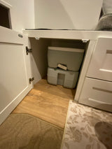 RV rental with clever storage: a compact portable toilet neatly hidden in a cabinet, perfect for mobile adventures.