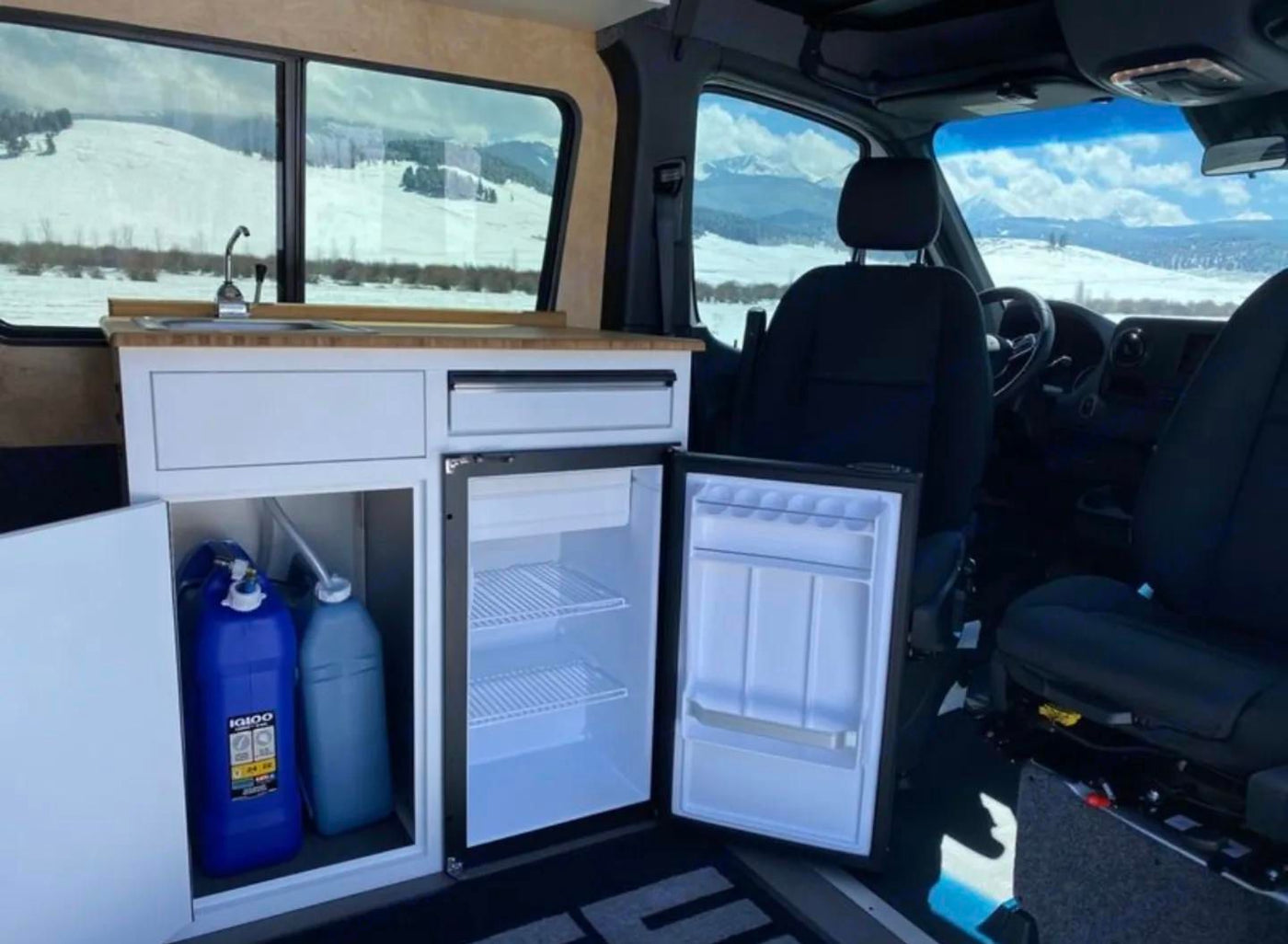  silhouetted mountains & trees. Epic adventure awaits.|Compact RV rental interior featuring a kitchenette — photo 11