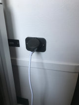 RV rental USB charger with a white cable plugged in, mounted on a light-colored interior wall for device power.