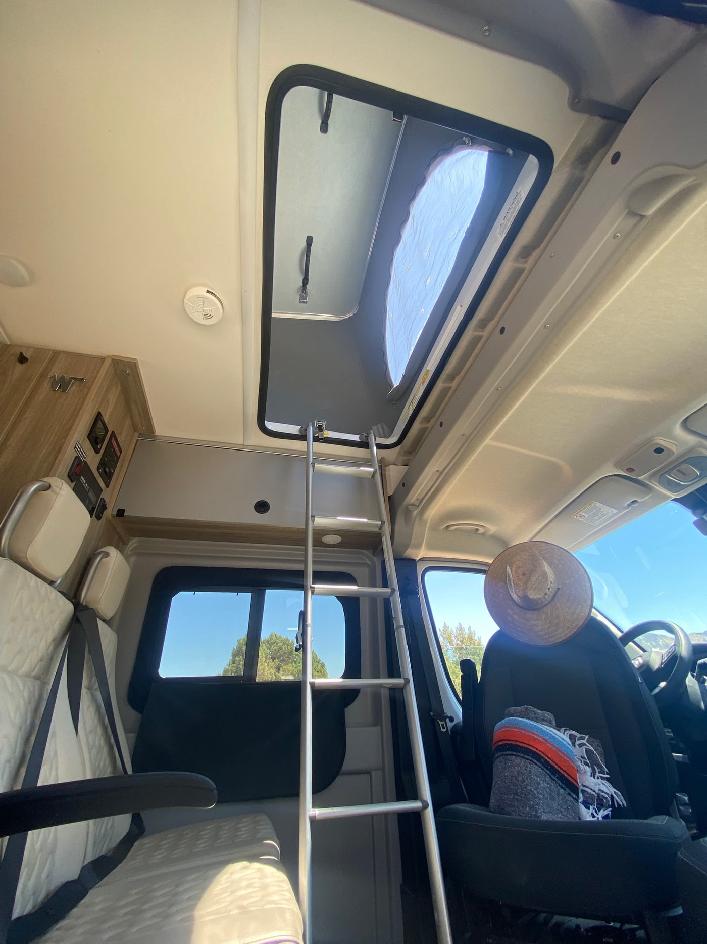  and driver's cabin with an outdoor view.|Inside an rv rental: a cozy bed overlooking a breathtaking desert sunset and mountain range. Ideal for off-grid camping.|RV rental kitchen: Sink caddy organizing hand soap — photo 24