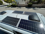 Top view of a white RV rental with multiple solar panels and roof vents, providing off-grid power for travel adventures.