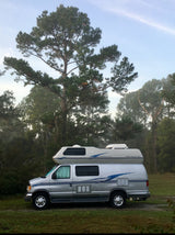 Silver Airstream 190 RV rental parked in a grassy, treed outdoor setting, ready for your next adventure.