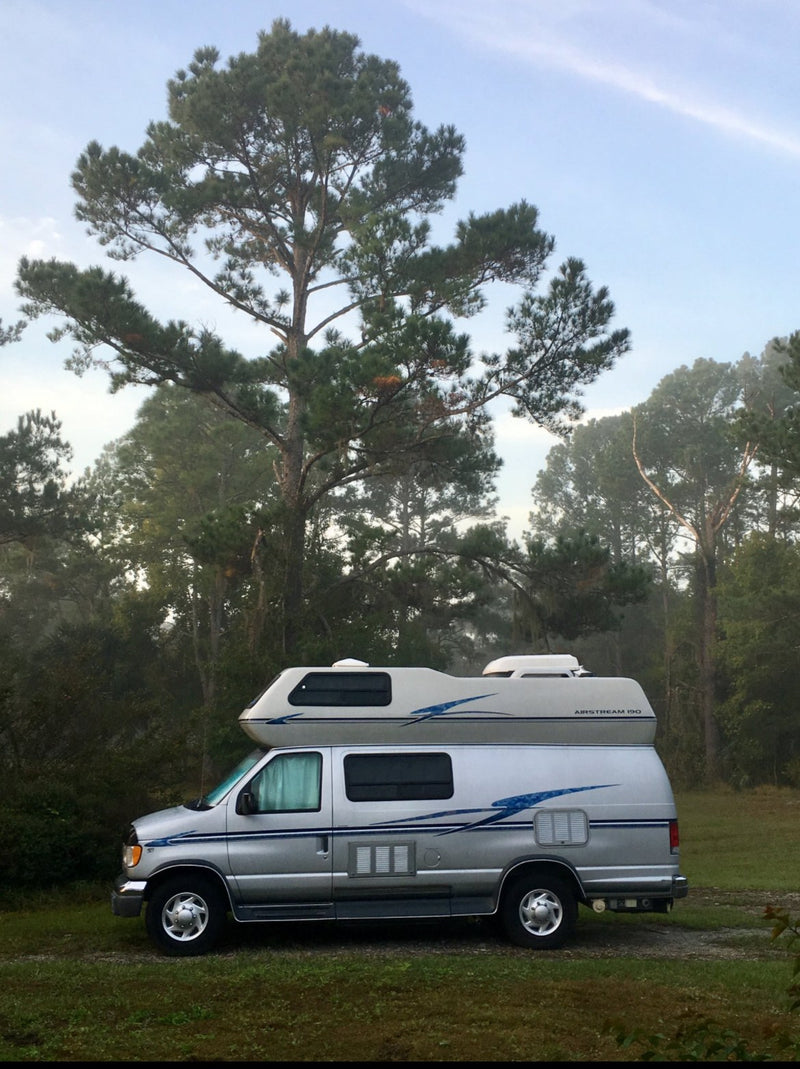 Silver Airstream 190 RV rental parked in a grassy, treed outdoor setting, ready for your next adventure. — photo 4