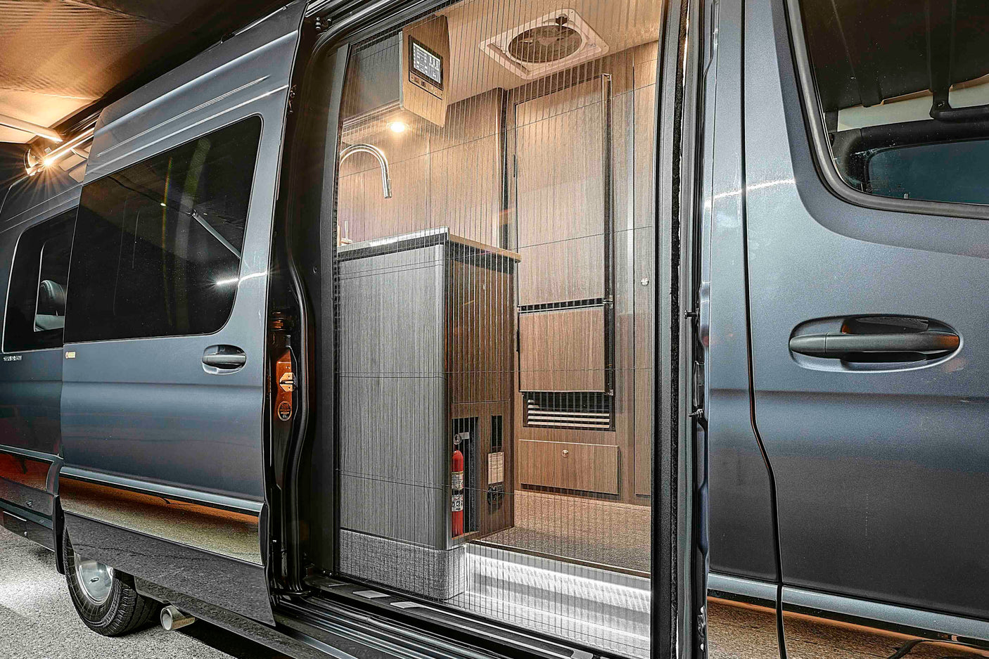 A sleek rv rental camper van with its side door open, revealing a functional interior & screen door for adventure.