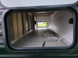 RV rental: Spacious pass-through storage bay, showing wooden framing, a window, and a Tire Linc system.