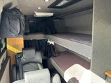 Inside this RV rental: modern camper van interior featuring bunk beds, swivel seats, overhead AC, and storage.