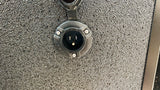 RV rental: Close-up of a NOCO three-pin electrical inlet, used for connecting to shore power.
