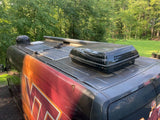 Overhead view of an RV rental van featuring multiple solar panels and a large AC unit on its roof.
