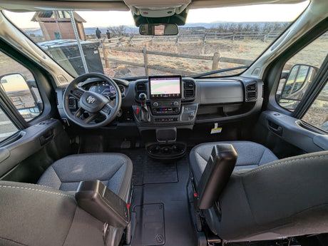 Step into this RV rental! Driver's view of a camper van's modern cockpit, dashboard screen, and outdoor scenic landscape.