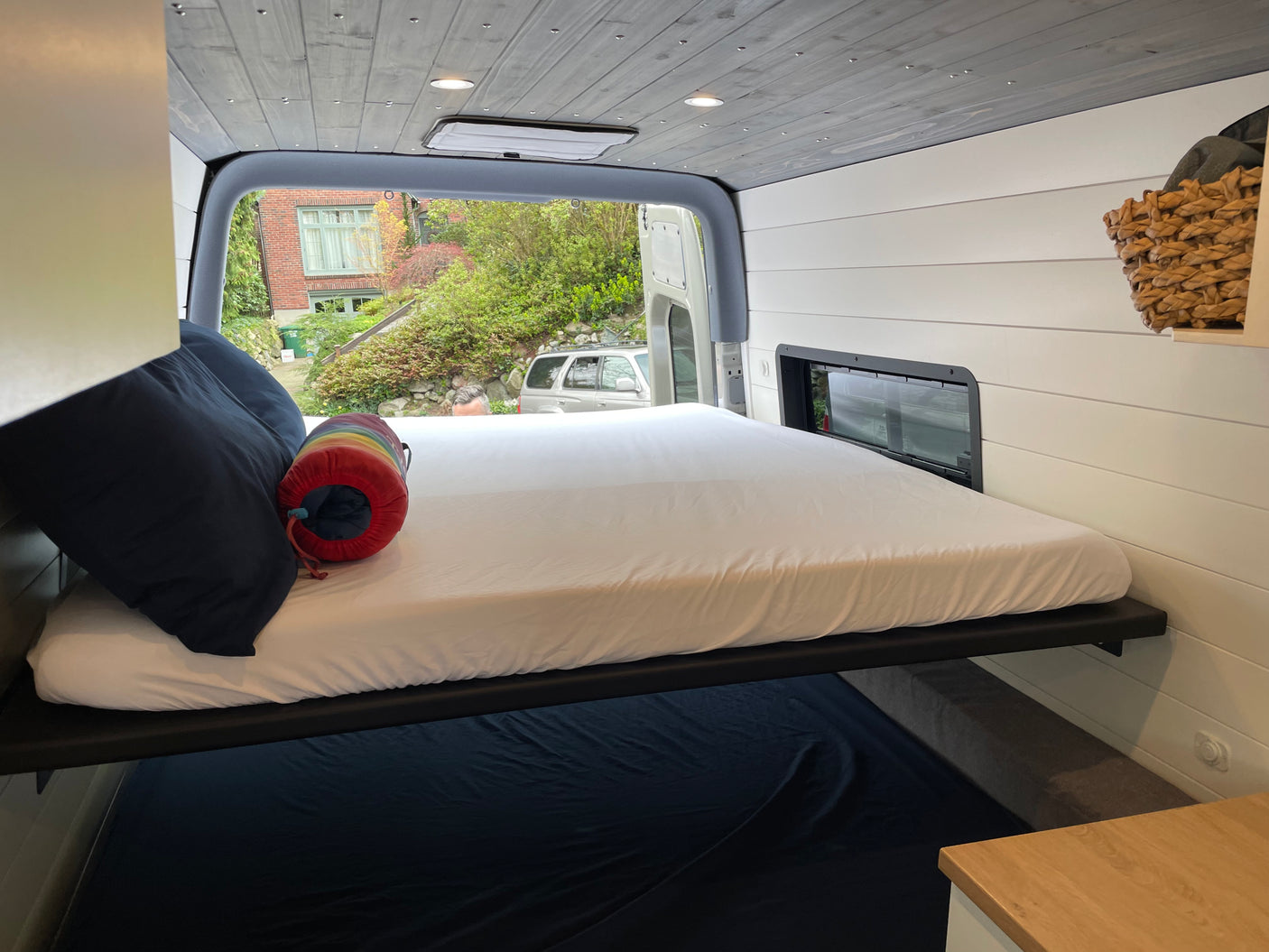 This RV rental offers a well-designed camper van interior with a cozy upper bed and practical lower sleeping space.