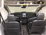 Spacious RV rental van interior, showing two dark front seats, the dashboard, and a sunshade on the windshield.
