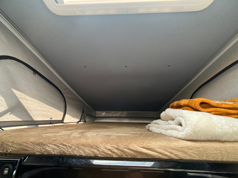 Inside an RV rental pop-top camper: a cozy bed with fluffy blankets and ceiling lights. Ready for adventure. — photo 10