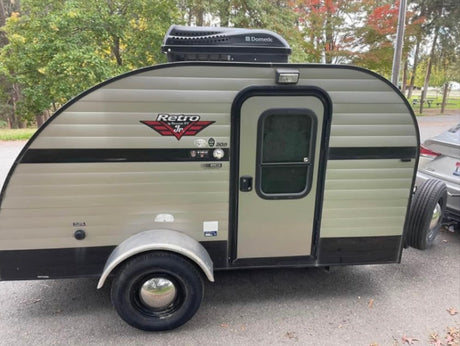 This beige & black retro-style teardrop travel trailer with Dometic roof box is perfect for your next RV rental camping trip!