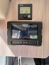 RV rental control panels: Truma thermostat & BMPRO smart system managing climate, lights, water pump, and tanks.