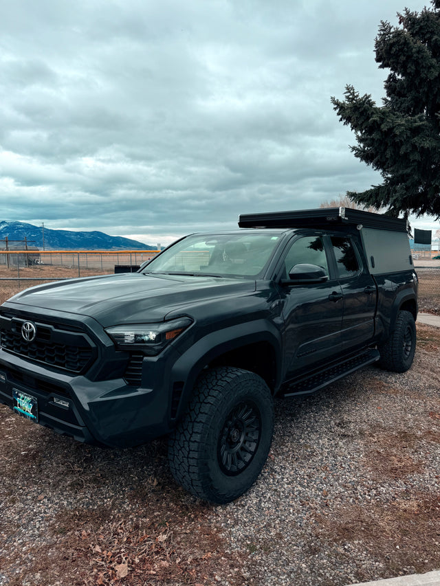 Adventure-ready Toyota Tacoma overland truck with a GFC camper, ideal for an **rv rental** camping trip or outdoor adventure.