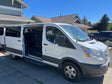 White passenger van with open doors displaying rows of seats, parked in a driveway. A versatile rv rental option for group travel.