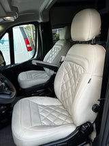 Experience comfort in this RV rental's interior: plush white quilted front seats, perfect for road trips and travel.