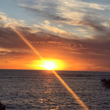 Stunning ocean sunset with sunbeams, perfect for an RV rental adventure. Experience scenic travel.