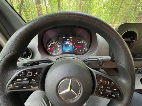 Interior view of an RV rental, showing the Mercedes-Benz steering wheel and dashboard with digital display indicating 72°F & 236 mi range.