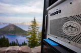 Storyteller Overland RV rental panel with a stunning view of Crater Lake and Wizard Island. Perfect for adventure travel.