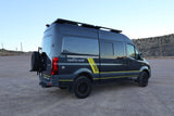 Dark gray custom 'Remote Vans' camper van with yellow stripes, roof rack, and rear spare tire, ideal for rv rental adventures.