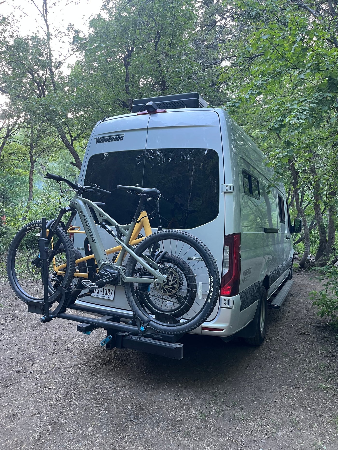 RV rental with bikes ready for forest adventures. A silver camper van and two mountain bikes parked on a dirt path. — photo 18