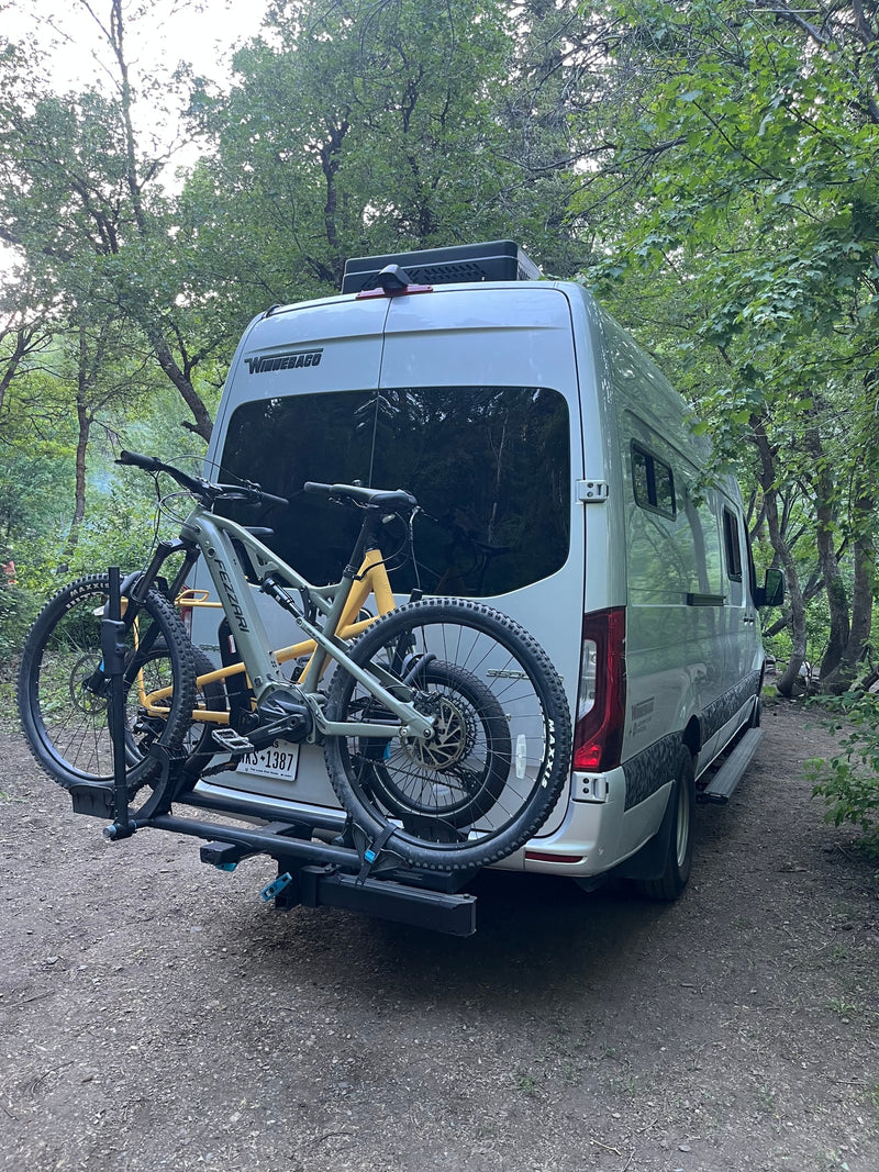 RV rental with bikes ready for forest adventures. A silver camper van and two mountain bikes parked on a dirt path. — photo 18