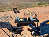 Scenic desert camping with an **rv rental**: a table, chairs, and coffee setup. Enjoying an outdoor meal in nature.