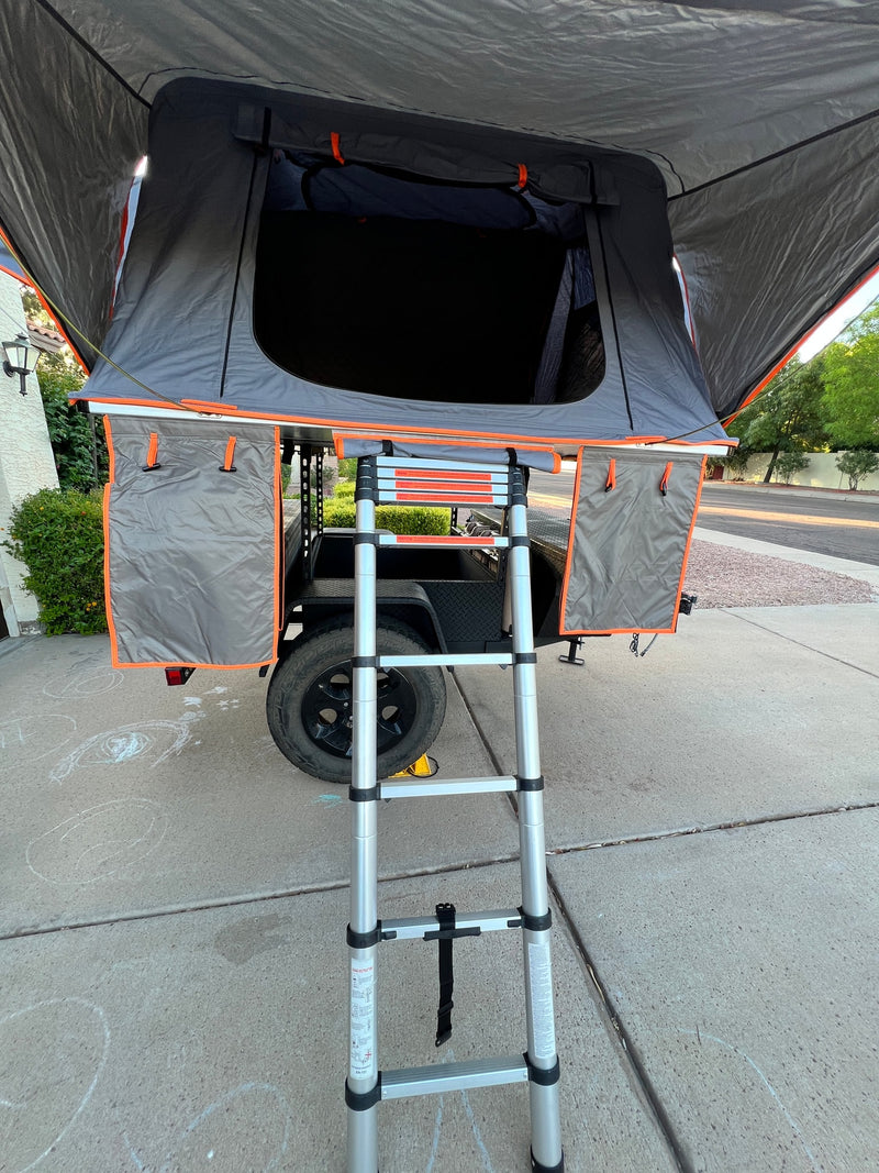 Grey and orange rooftop tent on a trailer, with its extended ladder. Perfect for an RV rental outdoor adventure. — photo 5