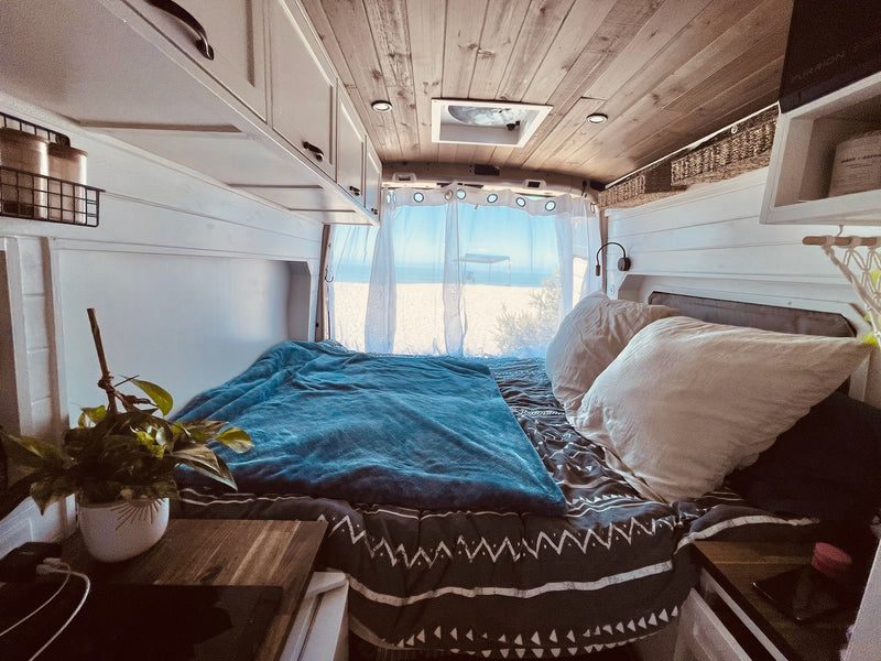 Experience comfort in this RV rental bedroom with a serene beach backdrop. Wooden ceiling — photo 1